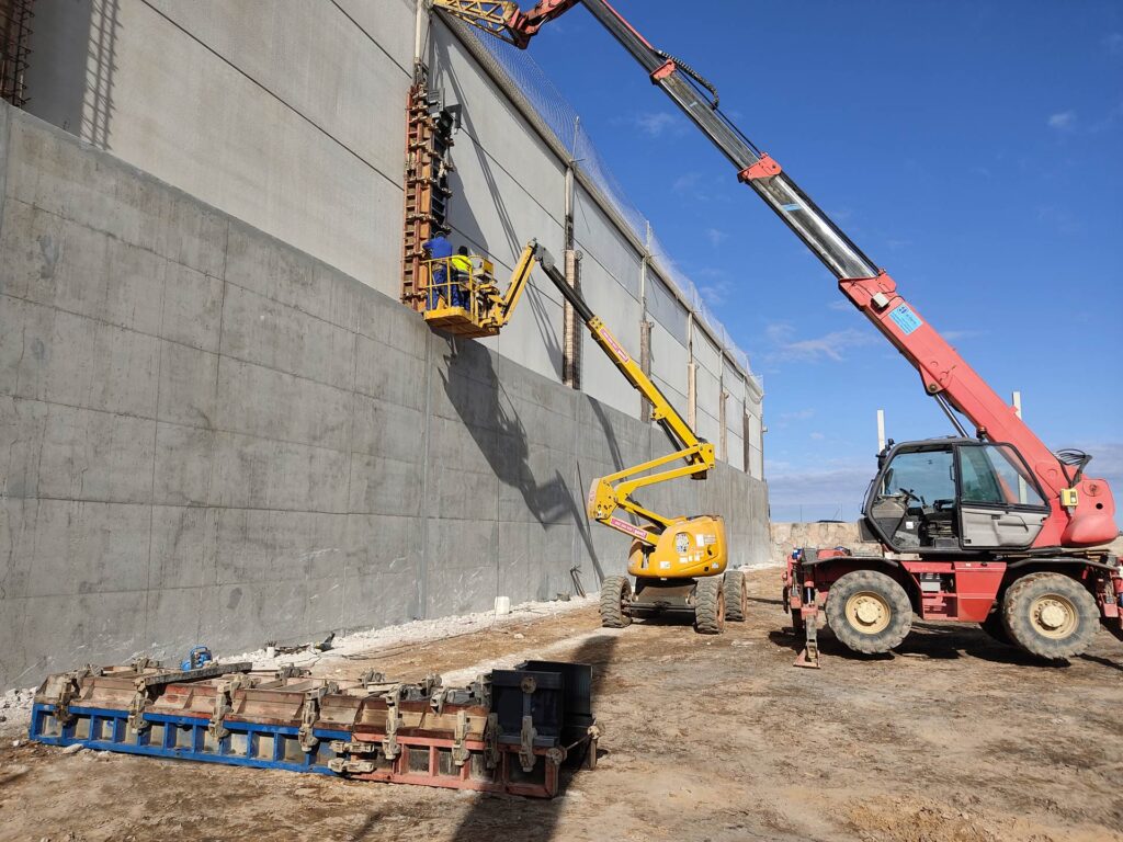 Máquinas trabajando en la reforma de un muro